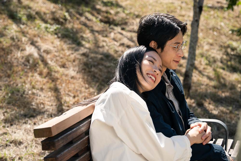 A couple sitting together happily on a bench