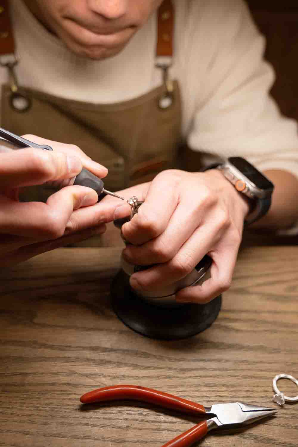 Hands working on an engagement ring at the bench