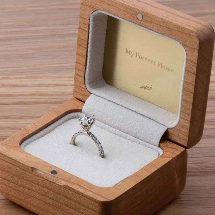 Diamond ring presented in a wooden ring box with engraved brass card